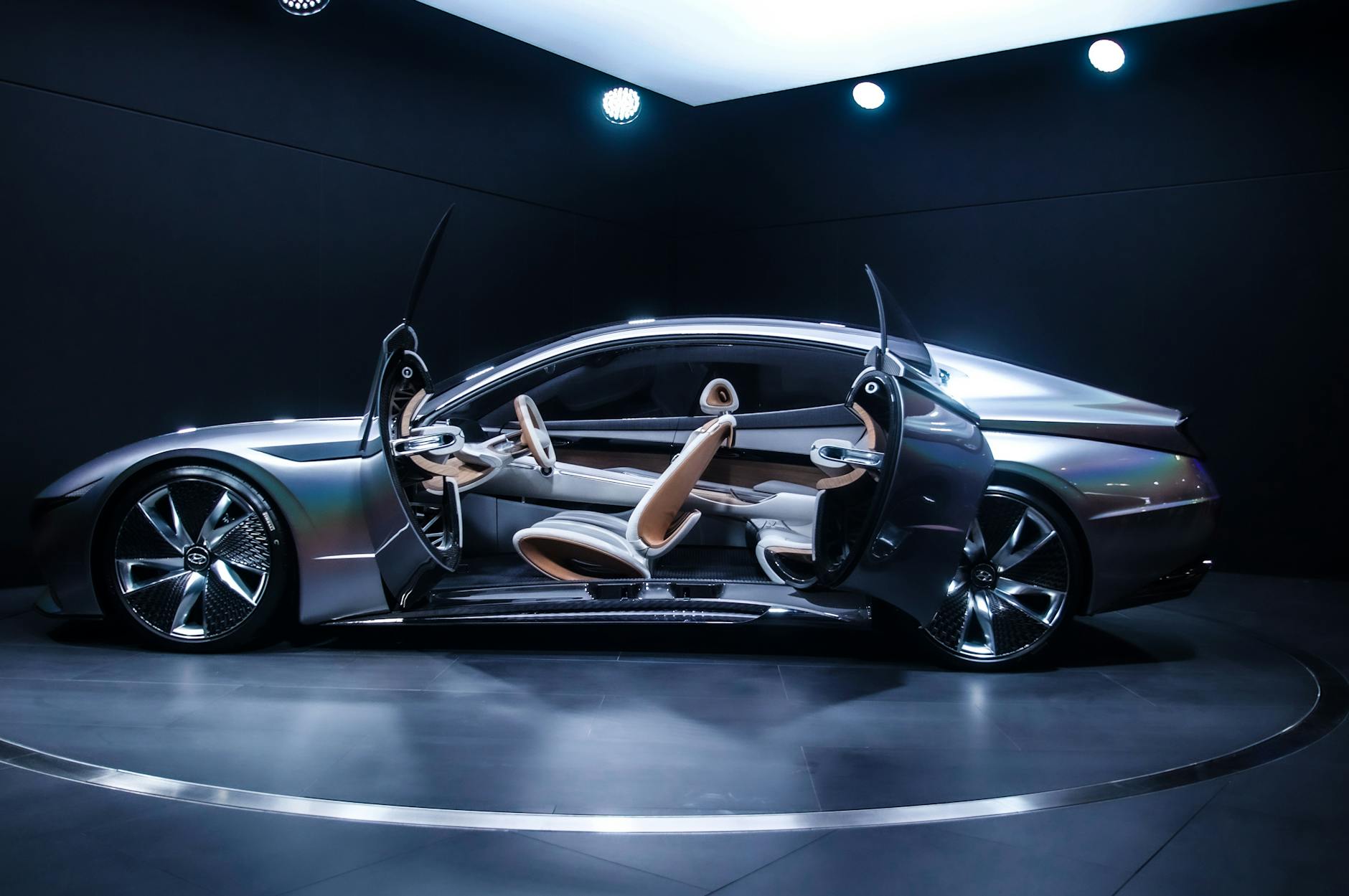 Ilustrasi: Sleek and modern concept car displayed indoors with open scissor doors, highlighting its futuristic design.
