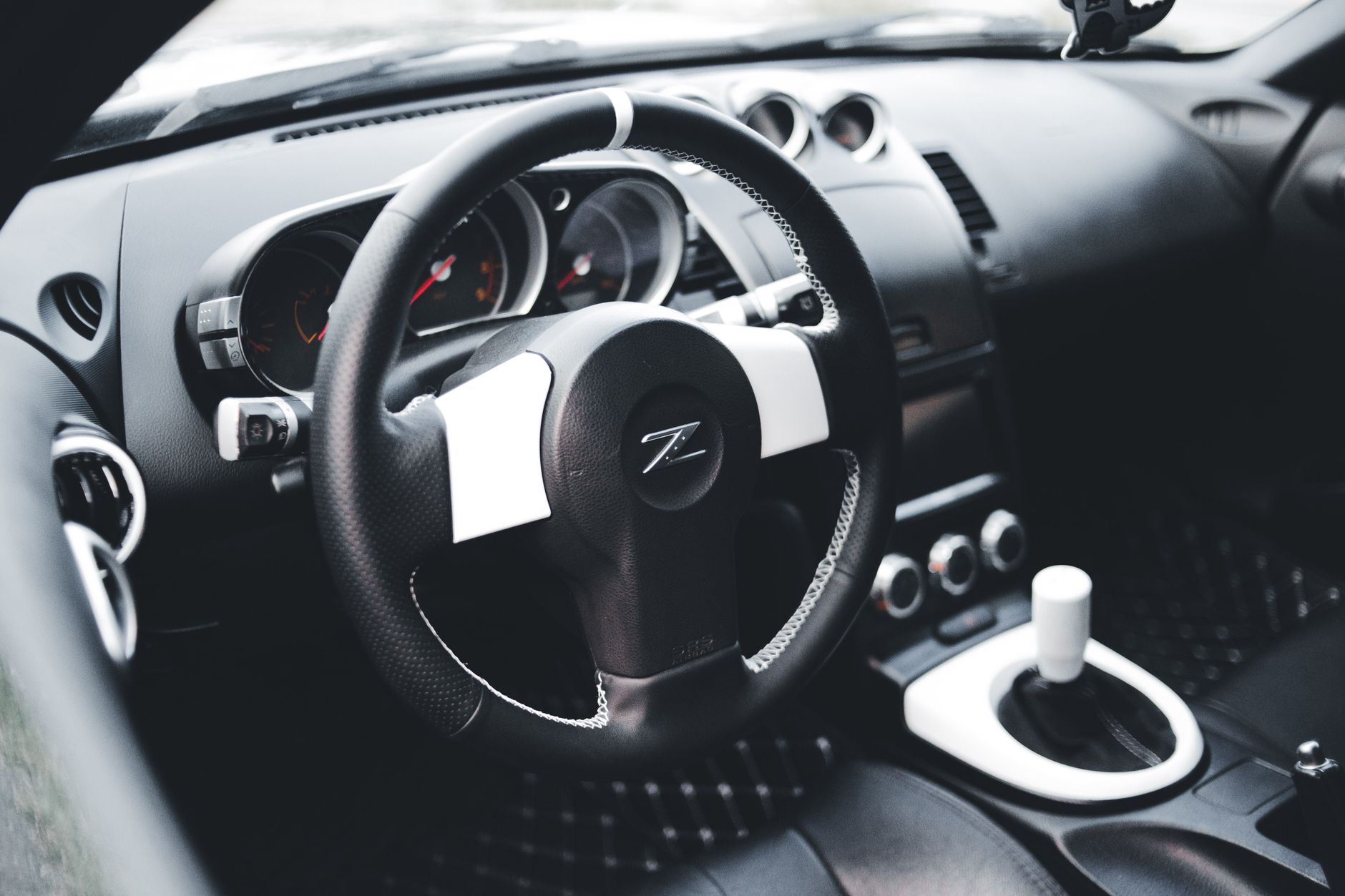 Ilustrasi: Modern Nissan car interior showcasing luxury dashboard and steering wheel with gear shift.