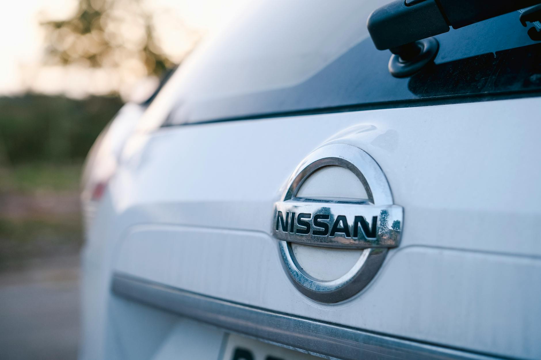 Ilustrasi: A close-up image of the logo on a Nissan car's trunk, highlighting the brand emblem in a sleek design.