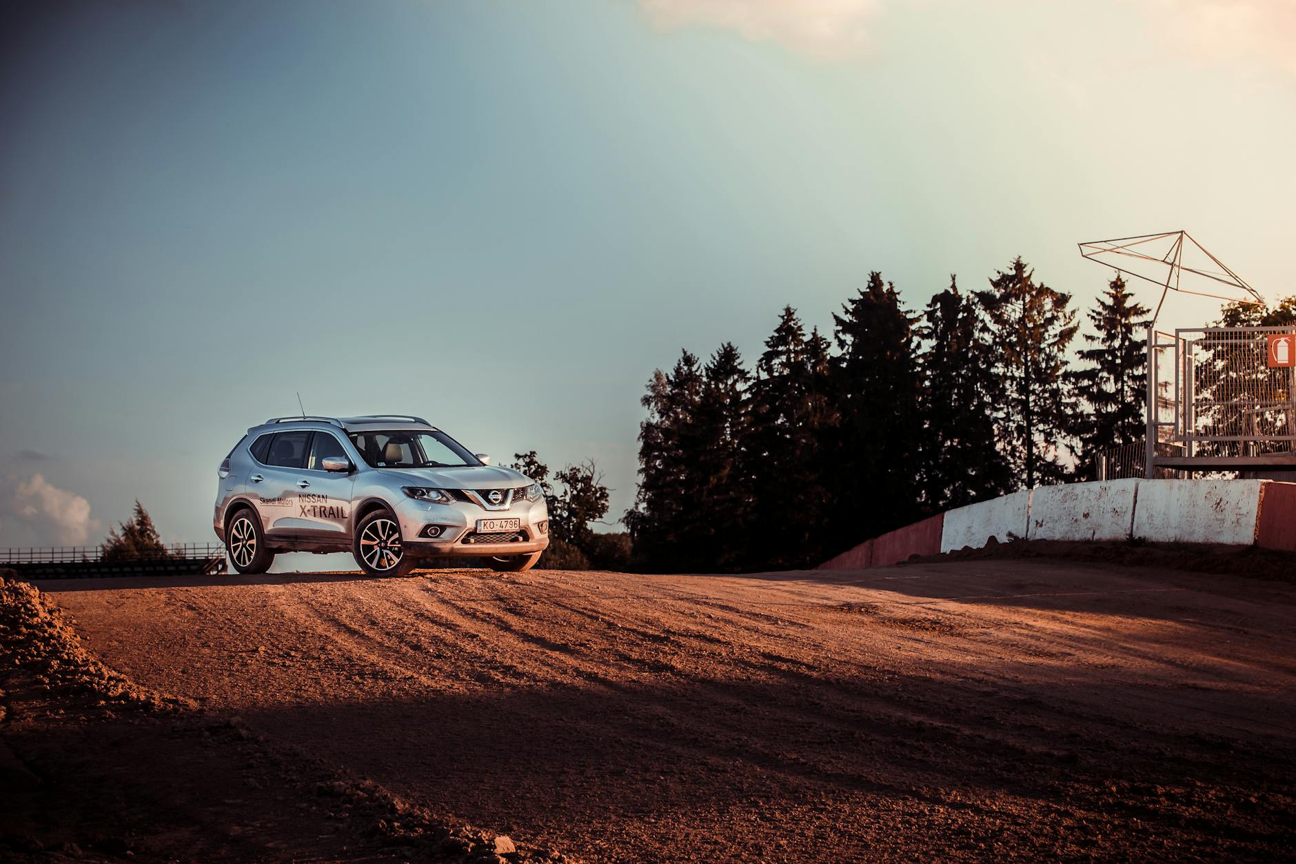Ilustrasi: A Nissan SUV parked on a dirt road, capturing the essence of adventure and nature at sunset.